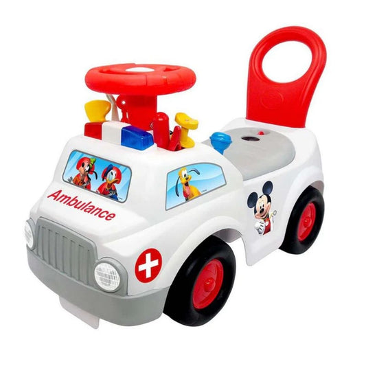 Vibrant multicolor Kiddieland Ambulance Ride-On featuring a sturdy white body with emergency graphics, a comfortable blue seat, easy-grip steering wheel, and a dashboard full of interactive light-up buttons.