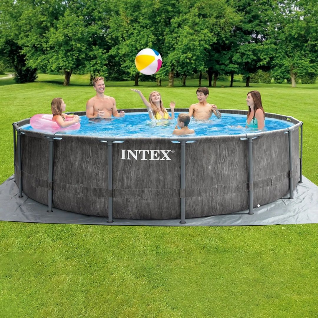 Intex Greywood Pool Set featuring a round pool with a realistic grey wood-grain exterior print and a white reinforced steel frame, shown with a family swimming inside.