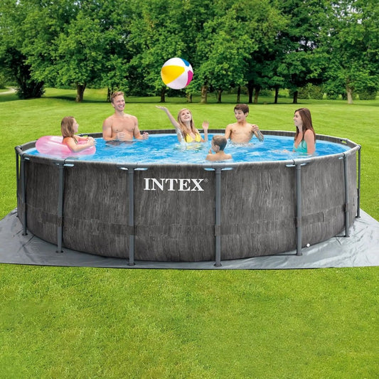Intex Greywood Pool Set featuring a round pool with a realistic grey wood-grain exterior print and a white reinforced steel frame, shown with a family swimming inside.