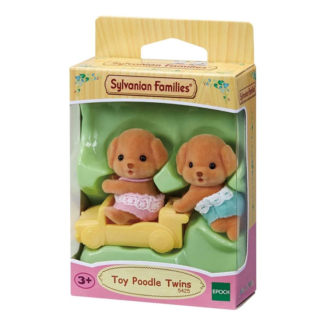 Vibrant multicolor Sylvanian Families Toy Poodle Twins featuring two soft-flocked puppy figures in pink and blue outfits with a small yellow push-along train toy.