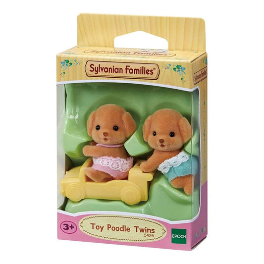 Vibrant multicolor Sylvanian Families Toy Poodle Twins featuring two soft-flocked puppy figures in pink and blue outfits with a small yellow push-along train toy.