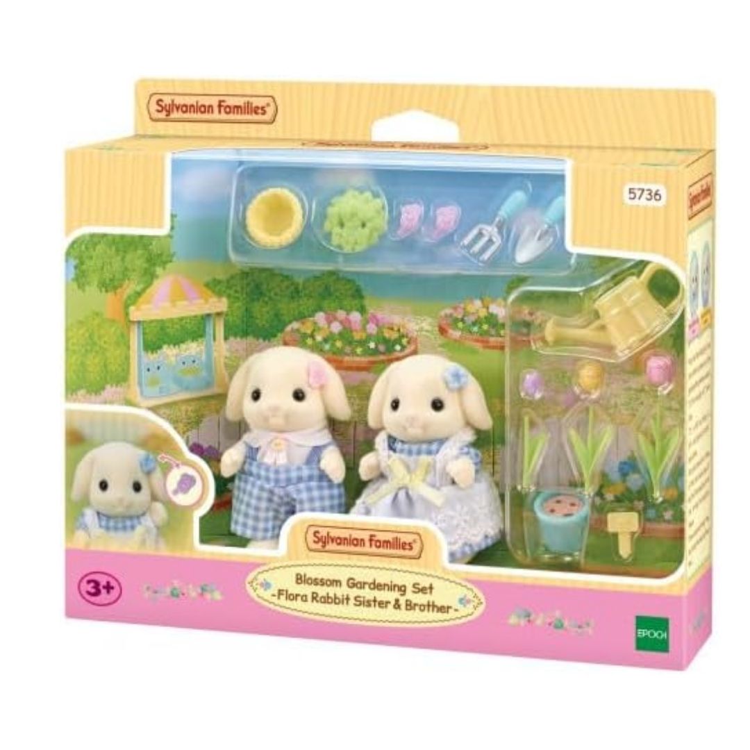 Vibrant multicolor Sylvanian Families Blossom Gardening Set featuring two drooping-ear Flora Rabbit figures in floral outfits with a wheelbarrow, watering can, and colorful flowerpot accessories.