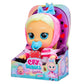Cry Babies Storyland Alice doll featuring a blue and white storybook-inspired outfit, blonde hair, and large expressive eyes, holding a matching pacifier in a multicolor display box.